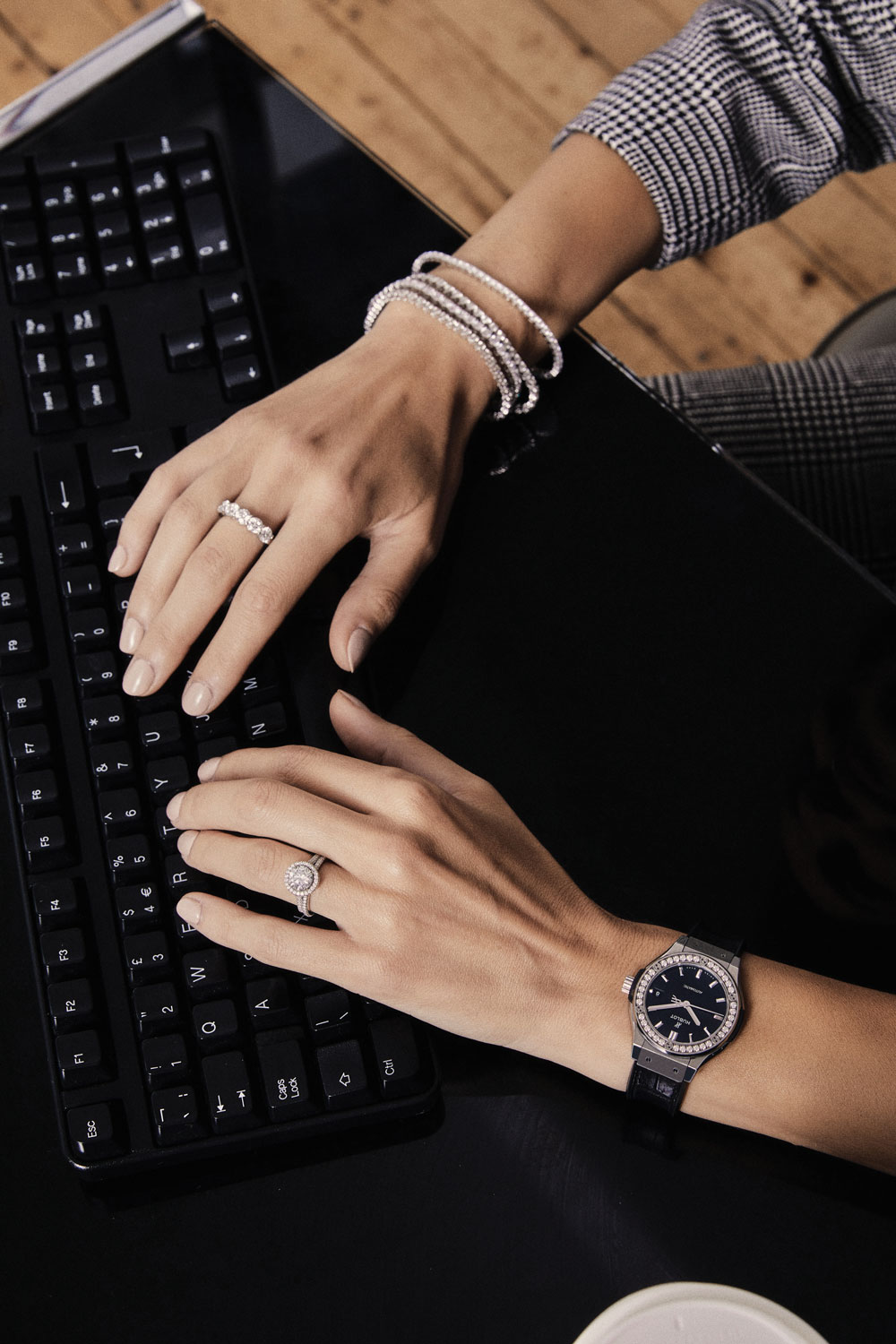 woman typing on keyboard wearing diamonds