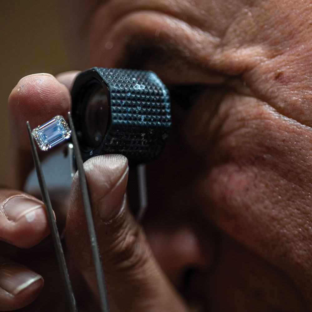 man looking at diamond through loupe